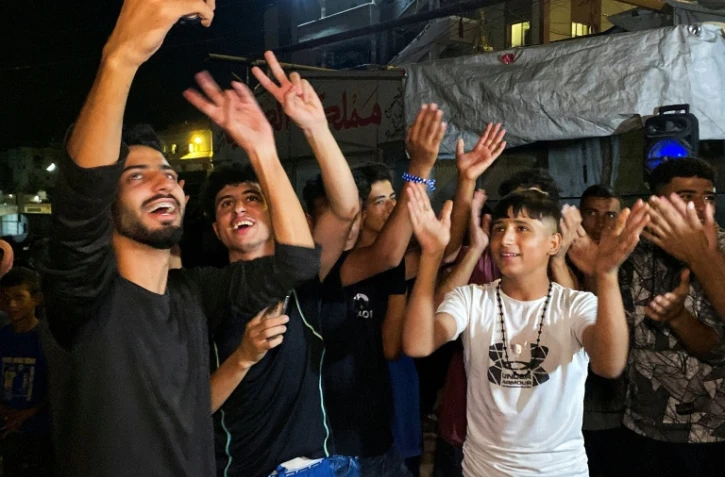 Des Palestiniens célèbrent l'annonce d'un cessez-le-feu entre le Hamas et Israël le 9 octobre 2025 à Khan Younès, dans la bande de Gaza. 