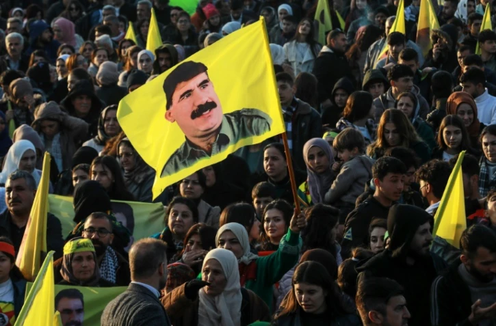 Un drapeau à l'effigie d'Abdullah Öcalan est brandi par des Kurdes syriens venus écouter son message, à Qamishli, dans le nord-est de la Syrie, le 27 février 2025