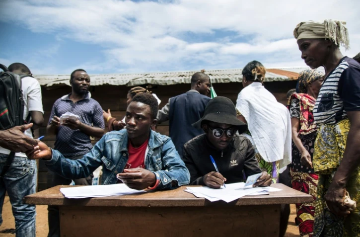 Des hommes s'inscrivent pour participer à un vote symbolique à Béni, en RDCongo, le 30 décembre 2018. Cette région est privée d'élections en raison de problèmes de sécurité et de la maladie d'Ebola