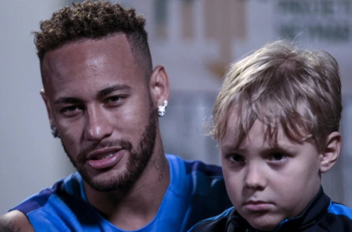 Neymar, avec son fils Davi Lucca, accorde un entretien à l'AFP, le 21 juillet 2018 à Praia Grande, près de Sao Paulo 