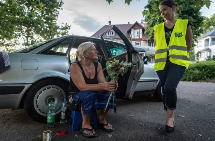 Gaelle une bénévole des Restos du coeur parle avec Marguerite, un SDF, photo du 30 juillet 2018