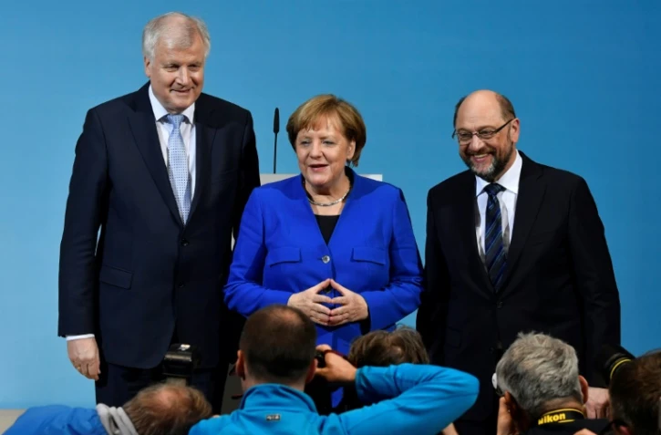 De gauche à droite, le leader de la CSU Horst Seehofer, la chancelière Angela Merkel et le leader du SPD Martin Schulz, au cours d'une conférence de presse à Berlin le 12 janvier 2018