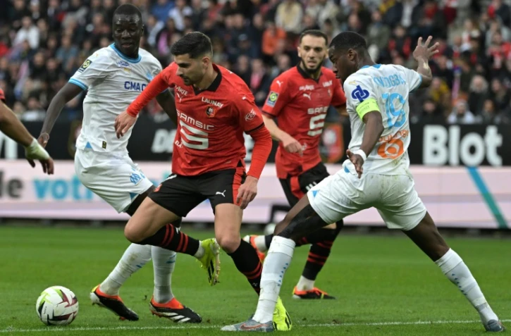 L'attaquant rennais Martin Terrier (c) entre les Marseillais Pape Gueye (g) et Geoffrey Kondogbia, le 17 mars 2024 Ă Rennes