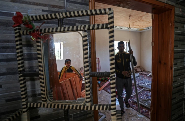 Des Palestiniens inspectent leur maison endommagée à Rafah, dans le sud de la bande de Gaza, le 14 mai 2023, dans les territoires palestiniens