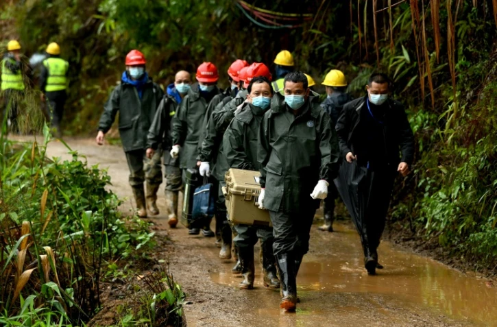 Des sauveteurs transportent une boîte près du site où un Boeing 737-800 de la China Eastern Airlines s'est écrasé, le 24 mars 2022 à Wuzhou, dans le sud de la Chine