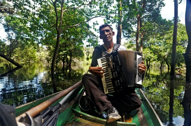 Le Brésilien Eder Rodrigues do Nascimento chante des chansons contre la déforestation et le changement climatique sur la rivière Jurua dans la région de Carauari au Brésil le 14 mars 2020