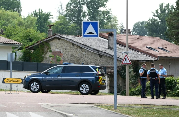 Des gendarmes bloquent une route menant à la maison où un homme a tué cinq personnes avant d'être abattu par le GIGN, le 20 juillet 2022 à Douvres, dans l'Ain