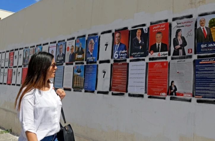 Une Tunisienne passe devant des affiches de campagne des candidats à la présidentielle, le 7 septembre 2019 à Tunis