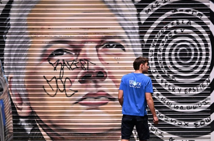Un homme passe devant une peinture murale représentant le fondateur de WikiLeaks, Julian Assange, dans une ruelle de Melbourne, en Australie, le 26 mars 2024