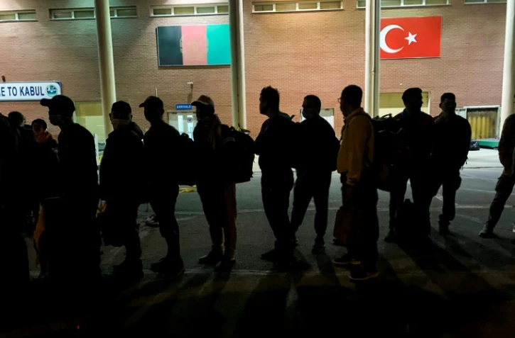 Des personnes patientent à l'aéroport de Kaboul le 17 août 2021 avant d'embarquer dans un avion militaire français
