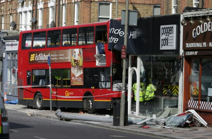 Des secouristes sur les lieux de l'accident où un bus s'est encastré dans la façade d'un cuisiniste à Londres, le 10 août 2017