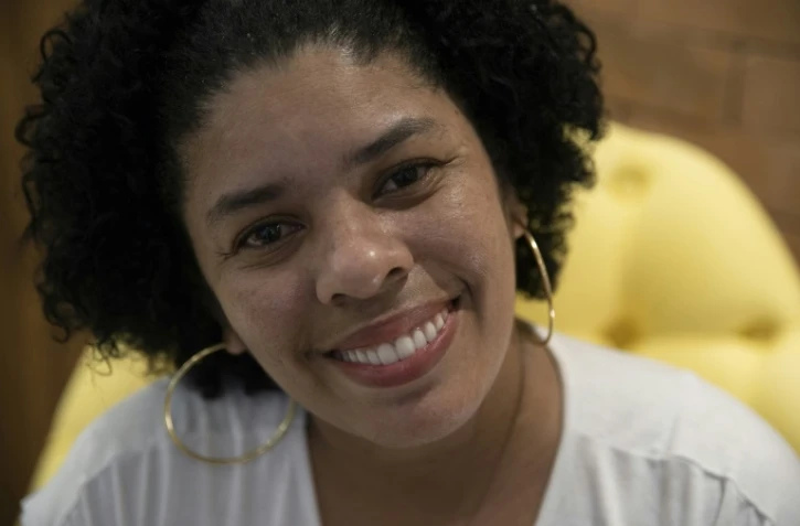 Ayant bénéficié de traitements de dentistes bénévoles pour récupérer une dentition détruite sous les coups de ses compagnons, Ana Claudia, 37 ans, sourit lors d'un entretien à l'AFP à Rio de Janeiro le 9 septembre 2019