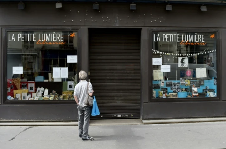 Un passant arrêté devant une librairie fermée, le 17 avril 2020 à Paris