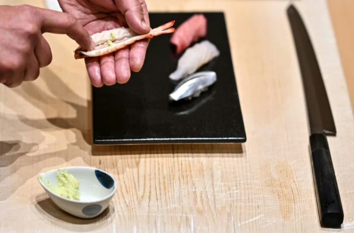 Le maître du sushi Toshiya Matsushita applique du wasabi frais à l'intérieur d'une crevette dans son restaurant de Tokyo, le 1er décembre 2020