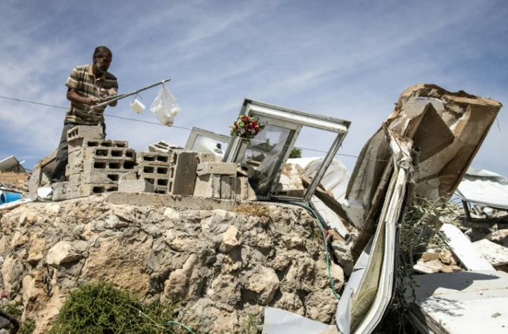 Un Palestinien récupère des objets dans les décombres d'une maison démolie dans le hameau de Khallet Al-Dabaa, en Cisjordanie occupée, le 6 mai 2025, après la destruction par les forces israéliennes des habitations de ce village
