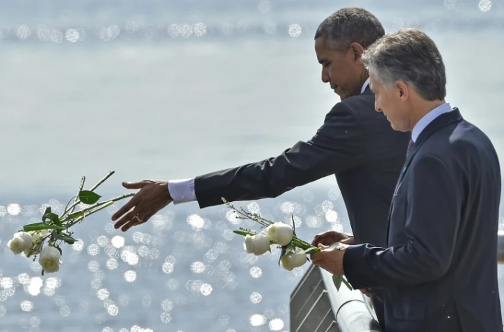 Les présidents américain Barack Obama et argentin  Mauricio Macri jettent des fleurs blanches dans River Plate en hommage aux victimes de la dictature le 24 mars 2016 à Buenos Aires 