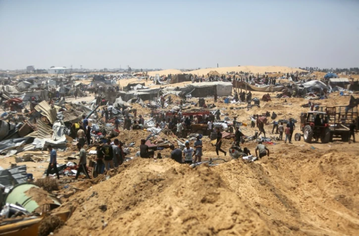 Des Palestiniens fouillent les débris d'un camp de déplacés près de Khan Younès, dans le sud de la bande de Gaza, au lendemain de ce que des témoins ont décrit comme une incursion de chars israéliens, le 11 juillet 2025