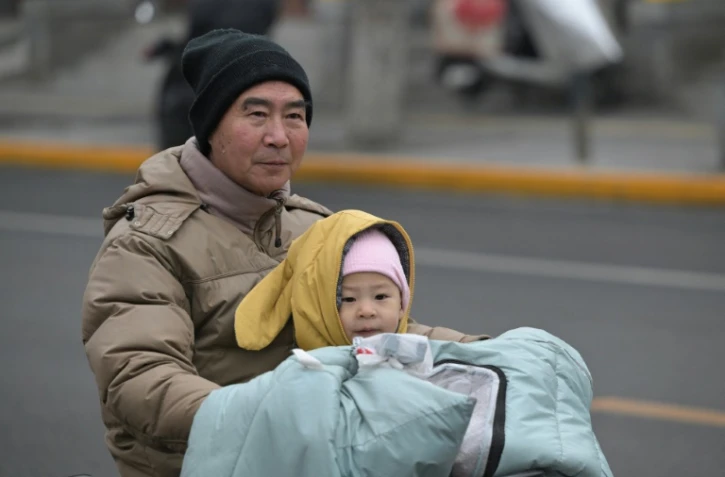 Un jeune enfant sur un scooter dans une rue de Pékin, le 17 janvier 2024