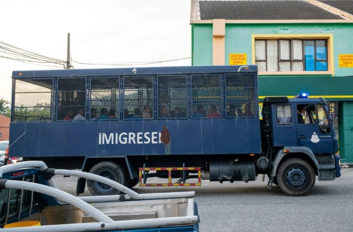Un camion des services d'immigration qui transporterait des migrants birmans se dirige le 23 février 2021 vers une base navale en Malaisie d'où les migrants ont été expulsés