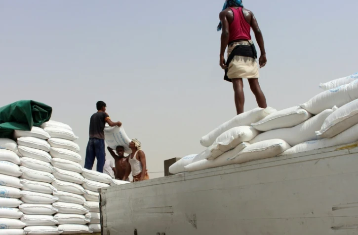 Des Yéménites déchargent des sacs d'aide alimentaire à destination des déplacés de la province de Hodeida, dans la province de Hajja, contrôlée par les Houthis, le 22 juin 2018