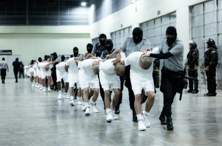 Photo diffusée le 16 mars 2025 par le service de presse de la présidence du Salvador montrant l'arrivée de membres présumés du gang vénézuélien Tren de Aragua au Centre d'Internement pour le Terrorisme (Cecot) à Tecoluca, au Salvador
