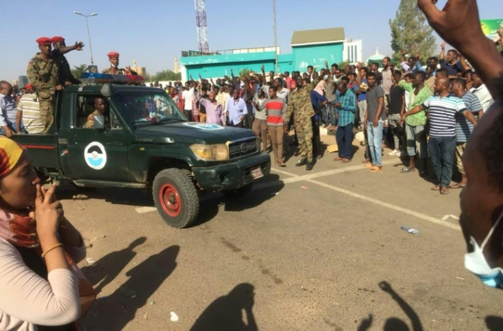 Des manifestants soudanais entourent un véhicule de l'armée à Khartoum, le 8 avril 2019