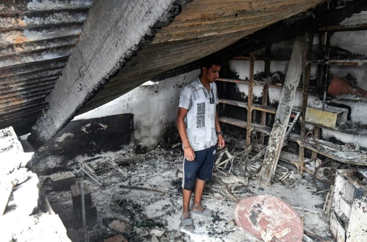 Un habitant dans les décombres de sa maison détruite par un feu de forêt, le 18 août 2022 à El Kala, en Algérie