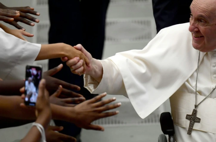 Le pape François serre des mains lors d'une audience avec des enfants de choeur venus de France dans la salle Paul VI au Vatican, le 26 août 2022

