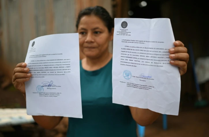Rosa Romero montre deux assignations du tribunal de Jucuaran pour libérer la parcelle où elle vit sur la plage d'El Higueron, le 20 juillet 2024 au Salvador