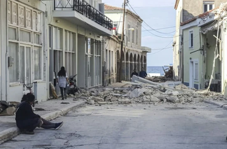 Des habitants près d'une maison détruite par un séisme sur l'île de Samos (Grèce), le 30 octobre 2020
