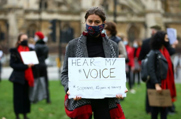 Une manifestante, chanteuse d'opéra, tient une pancarte "Entendez ma voix", le 30 octobre 2020 à Londres