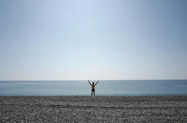 Un homme fait sa gymnastique au petit matin sur une plage de Nice, devant la Promenade des Anglais, le 19 mars 2020