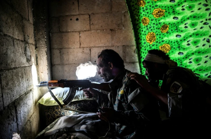 Des combattants des Forces démocratiques syriennes en position à l'intérieur d'un immeuble, le 5 octobre 2017 à Raqa 