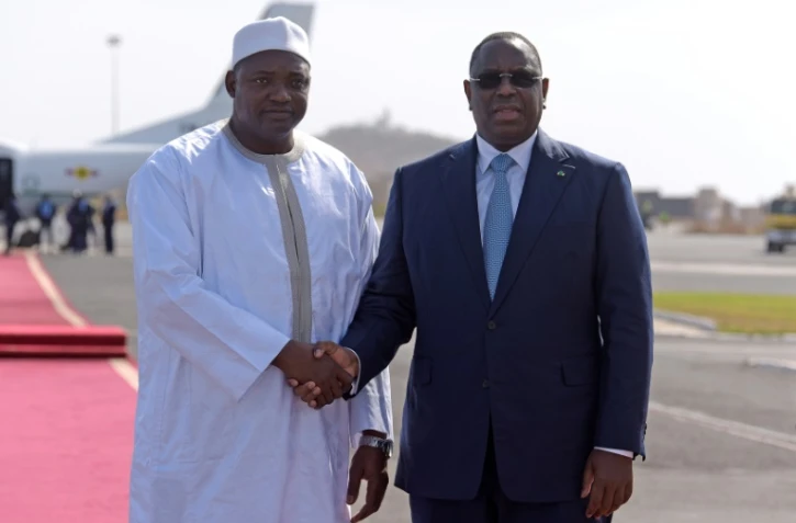 Poignée de mains entre le président sénégalais Macky Sall (d) et son homologue gambien Adama Barrow, le 26 janvier 2017 à Dakar