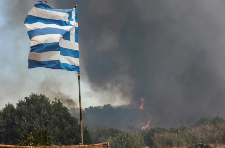 Un incendie se rapproche du village de Vatera, dans l'est de la station balnéaire populaire de l'île grecque de Lesbos, le 23 juillet 2022