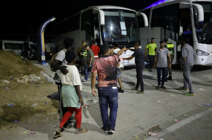 Des membres des forces de l'ordre marocaines acheminent par bus vers leurs villes d'origine des personnes qui avaient pénétré illégalement dans l'enclave espagnole de Ceuta, sur la côte nord du Maroc, le 1er août 2026 à Fnideq