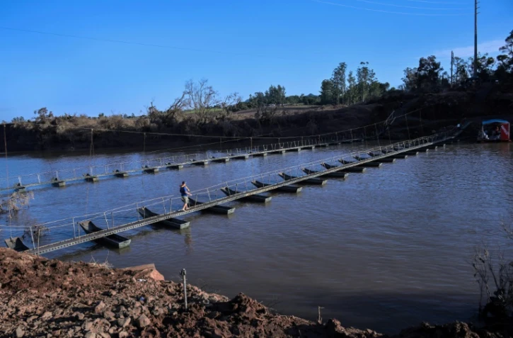 Un homme traverse la rivière Forqueta sur une passerelle flottante, à Lajeado, au Brésil, le 21 mai 2024