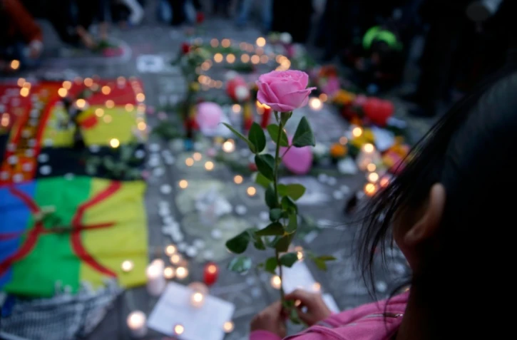Une fillette tient dans ses mains une rose et se mêle aux hommages aux victimes des attentats, place de la Bourse à Bruxelles, le 22 mars 2016