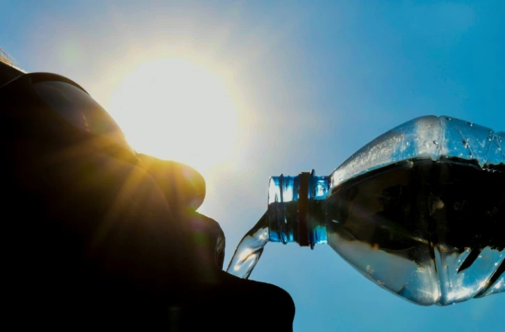 Un homme buvant alors que le soleil brille, à Lille, le 25 juillet 2018