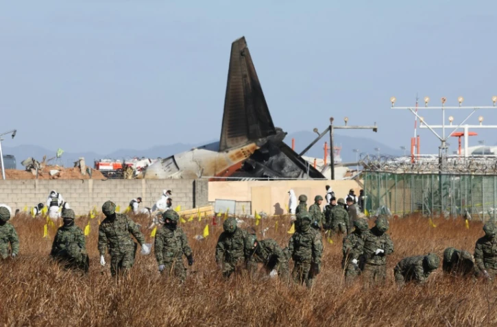 Des militaires effectuent des recherches aux alentours du lieu du crash du Boeing 737-800 de Jeju Air à Muan, en Corée du Sud, le 31 décembre 2024