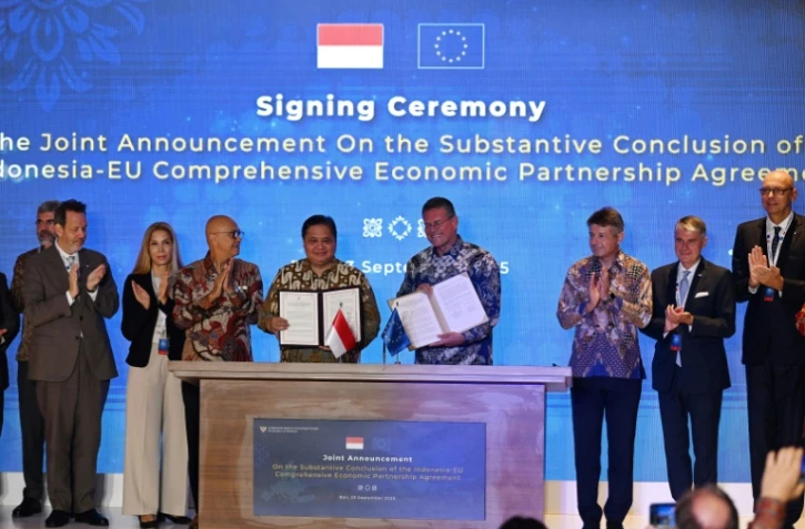 Le ministre indonésien de l'Economie, Airlangga Hartarto (au centre à g.), et le commissaire européen au commerce, Maros Sefcovic (au centre à d.), posent sur scène après avoir paraphé l'accord de libre-échange entre l'Indonésie et l'UE sur l'île indonésienne de Bali, le 23 septembre 2025