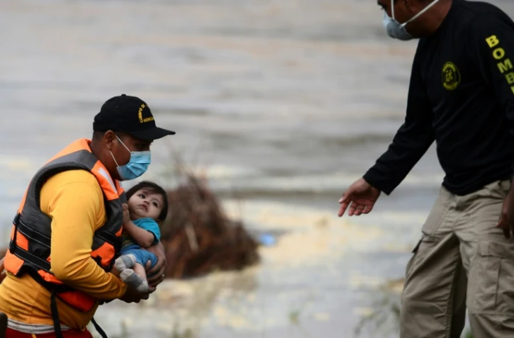 Des pompiers secourent des habitants après le passage de l'ouragan Eta dans le département de Yoro, à 240 kms au nord de Tegucigalpa, Honduras, le 7 novembre 2020