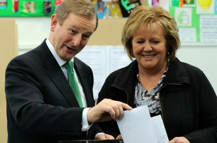 Le Premier ministre irlandais Enda Kenny (G) et son épouse Fionnuala placent leur bulletin dans l'urne à Castlebar, dans l'ouest de l'Irlande, le 26 février 2016