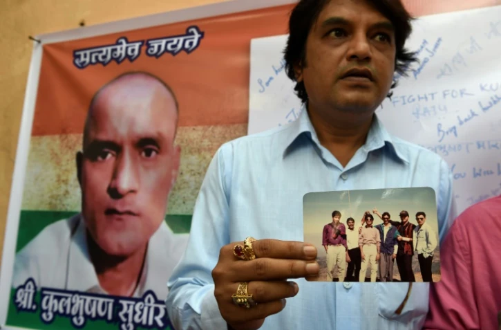 Des amis indiens de Kulbhushan Jadhav, condamné à mort au Pakistan, avec une photo où il figure en leur compagnie, à Mumbai le 18 mai 2017