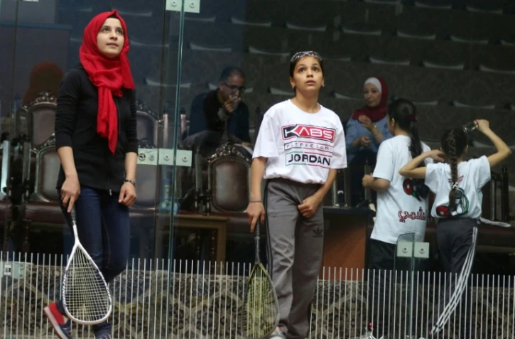 La réfugiée syrienne Raghda (c) joue au squash, le 18 novembre 2017 à Amman, en Jordanie