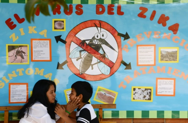 Une mère et son enfant devant un panneau expliquant le virus de Zika, à Tegucigalpa, au Honduras, le 26 février 2016