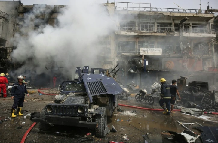 Des pompiers sur les lieux de l'attentat dans le quartier à majorité chiite de Jadida à Bagdad, le 9 juin 2016