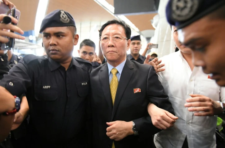 L'ambassadeur expulsé de la Corée du Nord, Kang Chol (c) escorté par des policiers dans le hall de départ de l'aéroport de Kuala Lumpur, en Malaisie, le 6 mars 2017