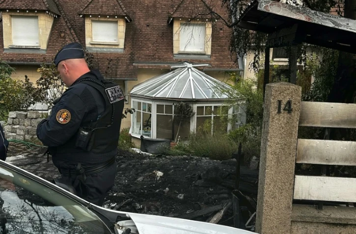 Un policier municipal se tient devant la maison endommagée du maire de L'Haÿ-les-Roses Vincent Jeanbrun dans cette ville du Val-de-Marne, le 2 juillet 2023