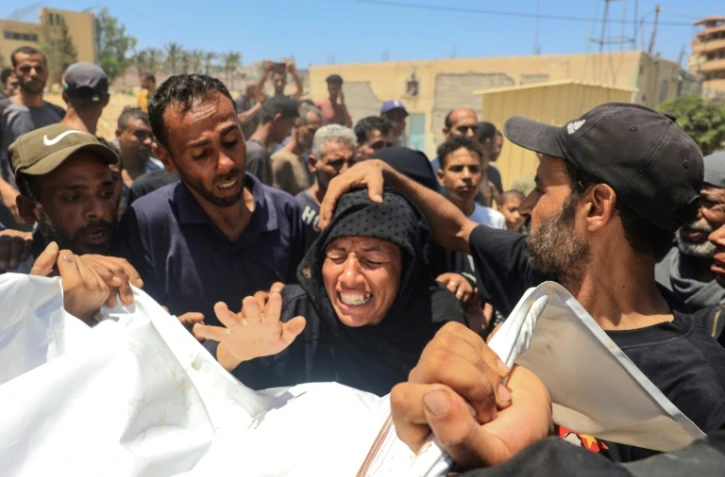 Une Palestinienne réagit devant le cadavre d'un membre de sa famille à la morgue de l'hôpital Nasser de Khan Younès après une frappe sur le camp d'al-Mawasi, le 13 juillet 2024